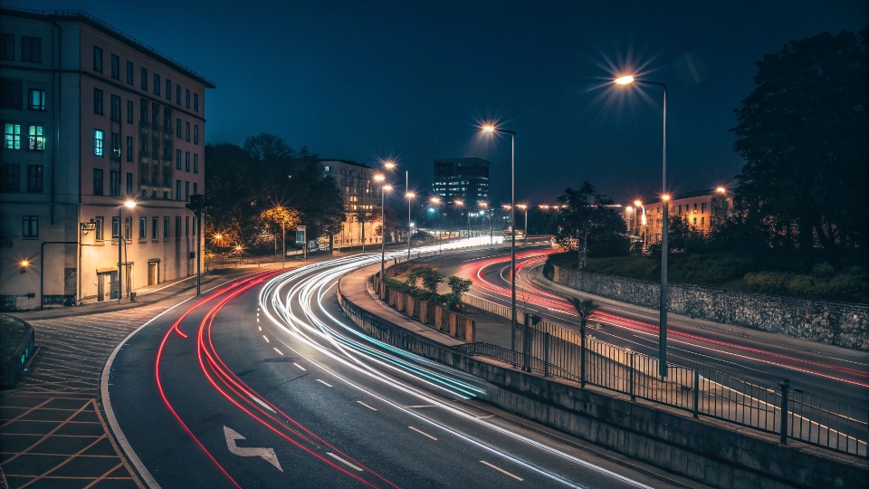 A long exposure shot of a street at night with light trails from cars